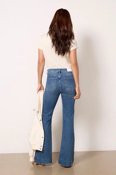 Model wearing Kinsley Flare Jeans in light wash denim, featuring a high-rise fit, flared leg, and vintage-inspired fading