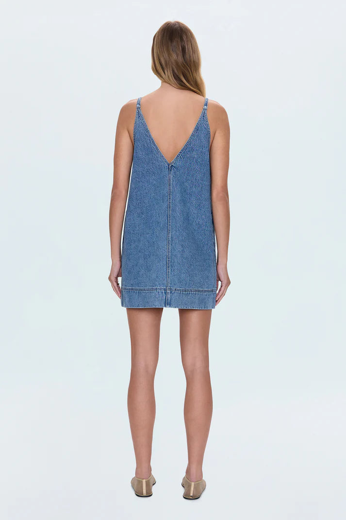 Back view of the Tavi Pop Over Dress in Palms featuring a deep V-shaped back, adjustable straps, and relaxed A-line shape in mid-wash denim.