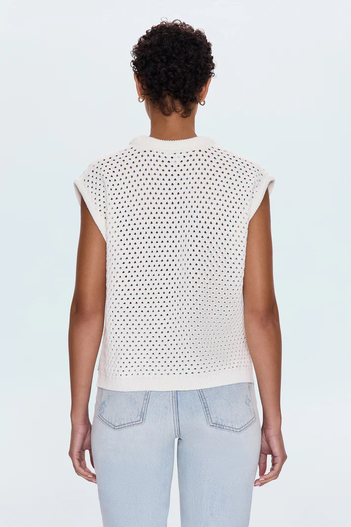 Back view of the Beck Open Knit Cropped Sweater showing full open-knit detailing, ribbed hem, and cap sleeves in a relaxed ivory cotton knit, paired with high-waisted light jeans.