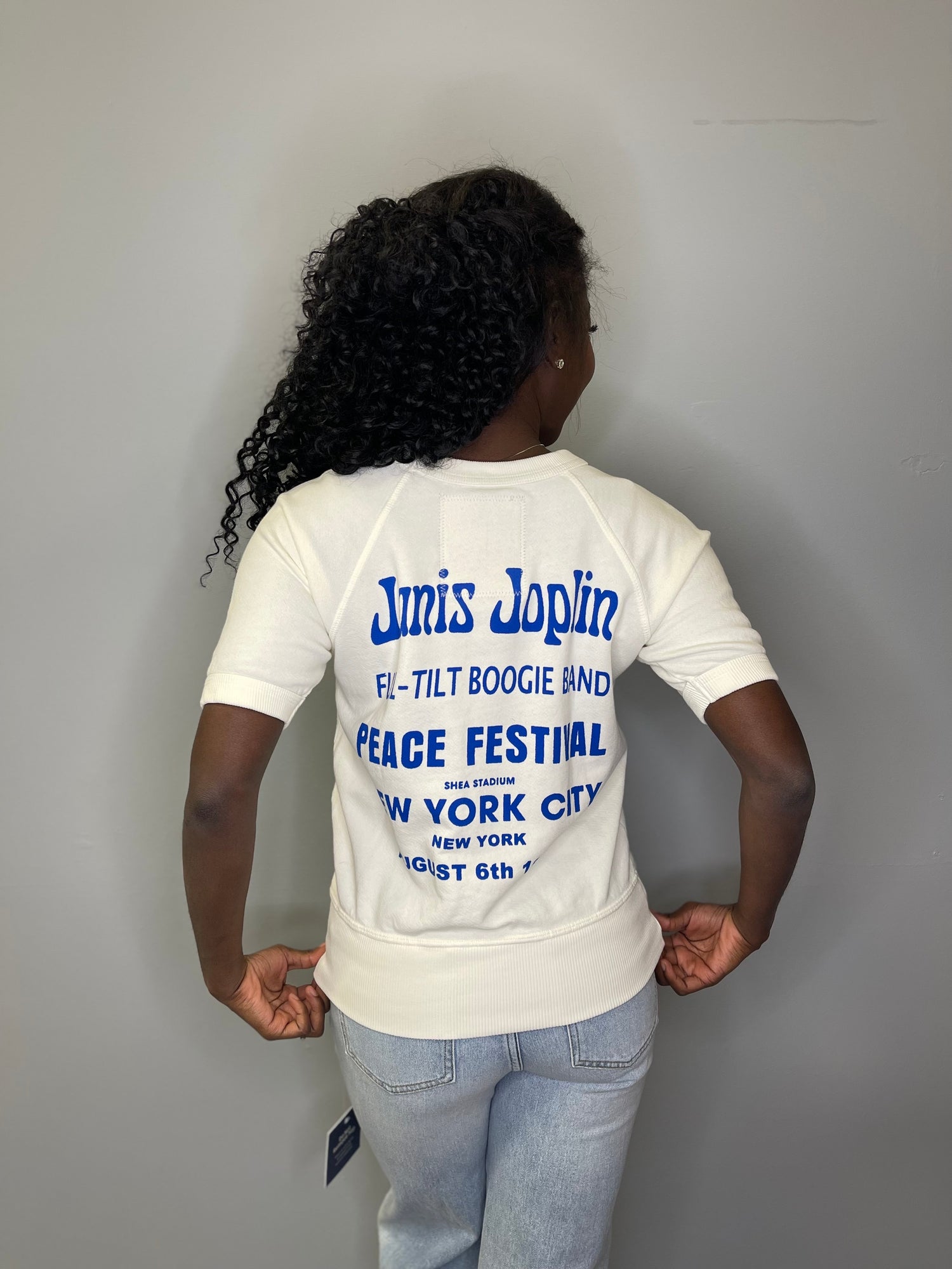 Back view of the model in the Janis Joplin Peace Festival tee, revealing the bold blue vintage concert print honoring the NYC Shea Stadium show.