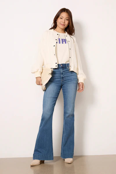 Model wearing Kinsley Flare Jeans in light wash denim, featuring a high-rise fit, flared leg, and vintage-inspired fading