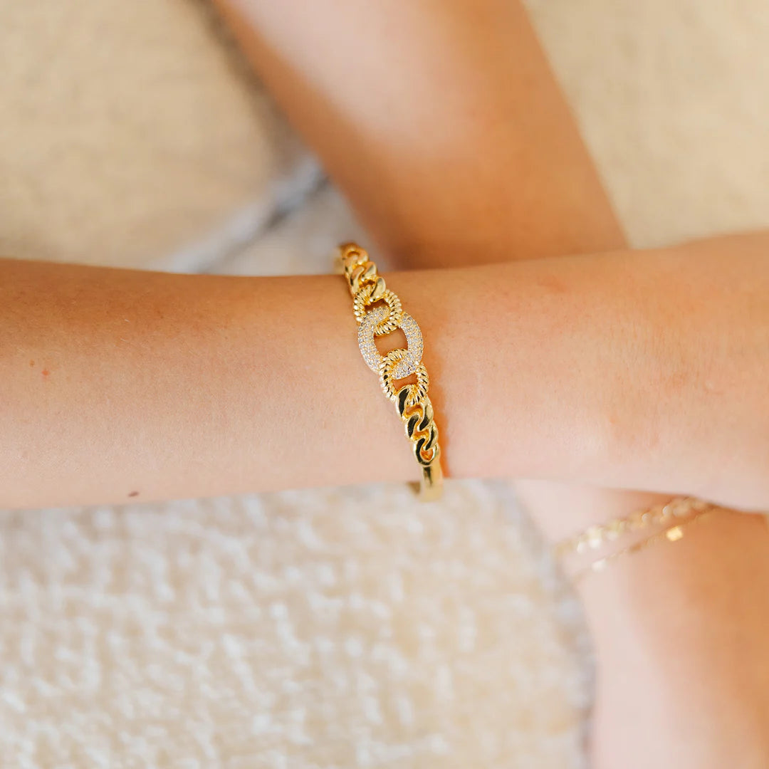 Leah Bangle in gold with chain-link design and sparkling cubic zirconia accents.