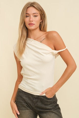 Woman wearing an ivory one-shoulder top paired with dark-wash jeans, shown from the back – product showcase for Sloan's Formal Boutique