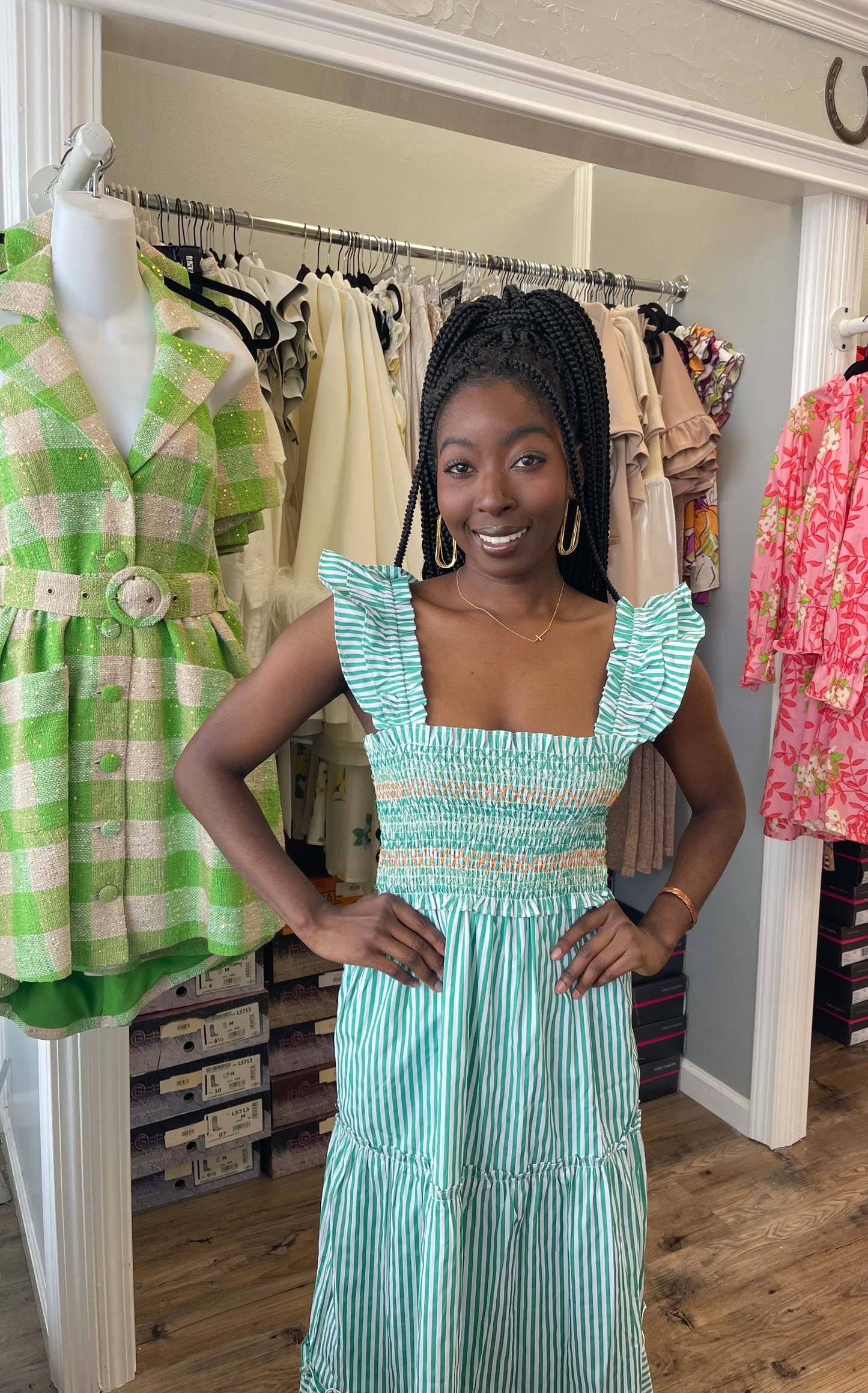 Model wearing the Peal Maxi Dress in green, featuring a tiered full-length skirt, fitted bodice, and delicate ruffle detailing.