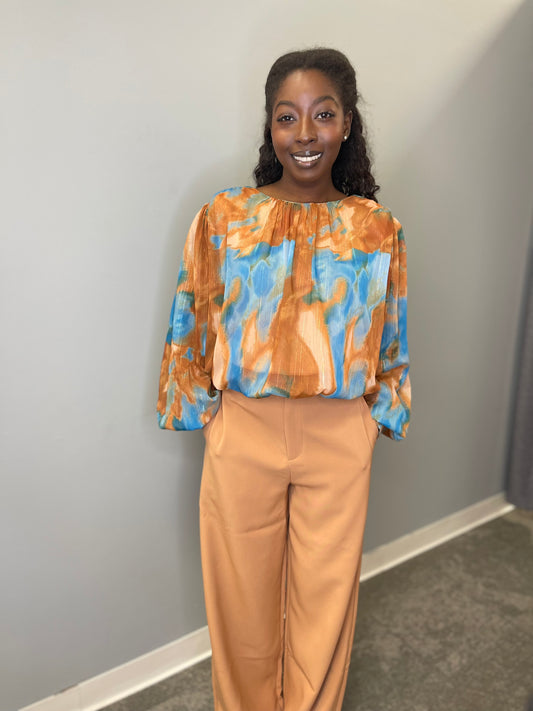 Model wearing the Evermore Woven Top in brown and blue abstract pattern, featuring a relaxed fit and lightweight fabric.