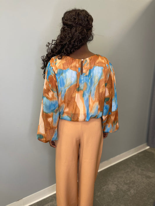 Model wearing the Evermore Woven Top in brown and blue abstract pattern, featuring a relaxed fit and lightweight fabric.