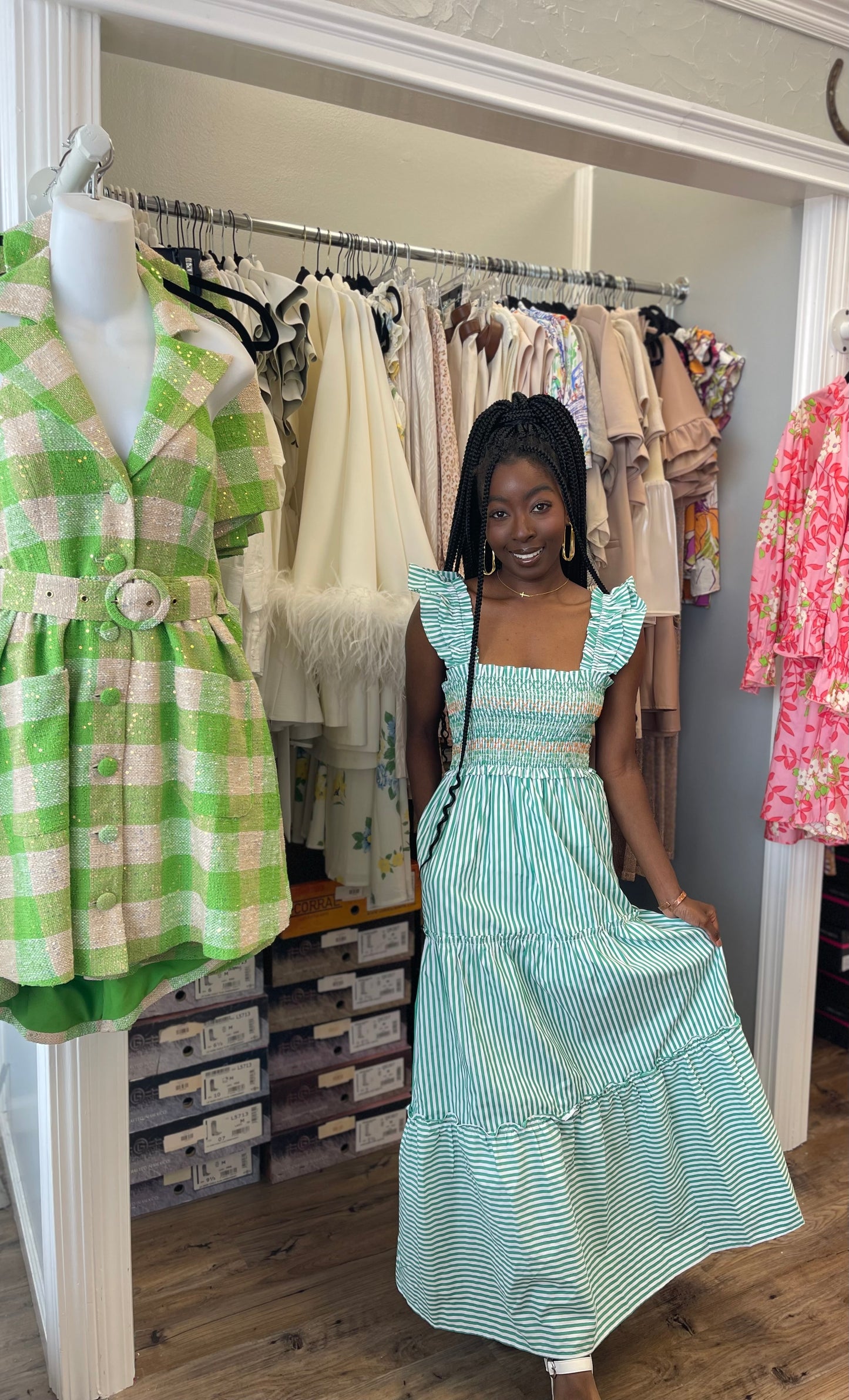 Model wearing the Peal Maxi Dress in green, featuring a tiered full-length skirt, fitted bodice, and delicate ruffle detailing.