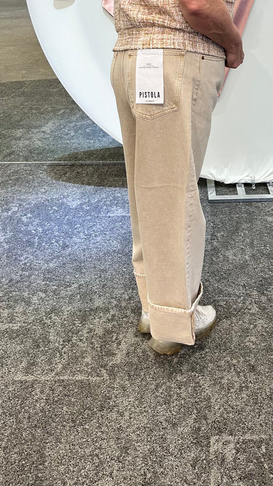Model wearing the Ryder Cuffed Jeans in tan, featuring a straight-leg fit, cuffed hems, and structured mid-rise waist.