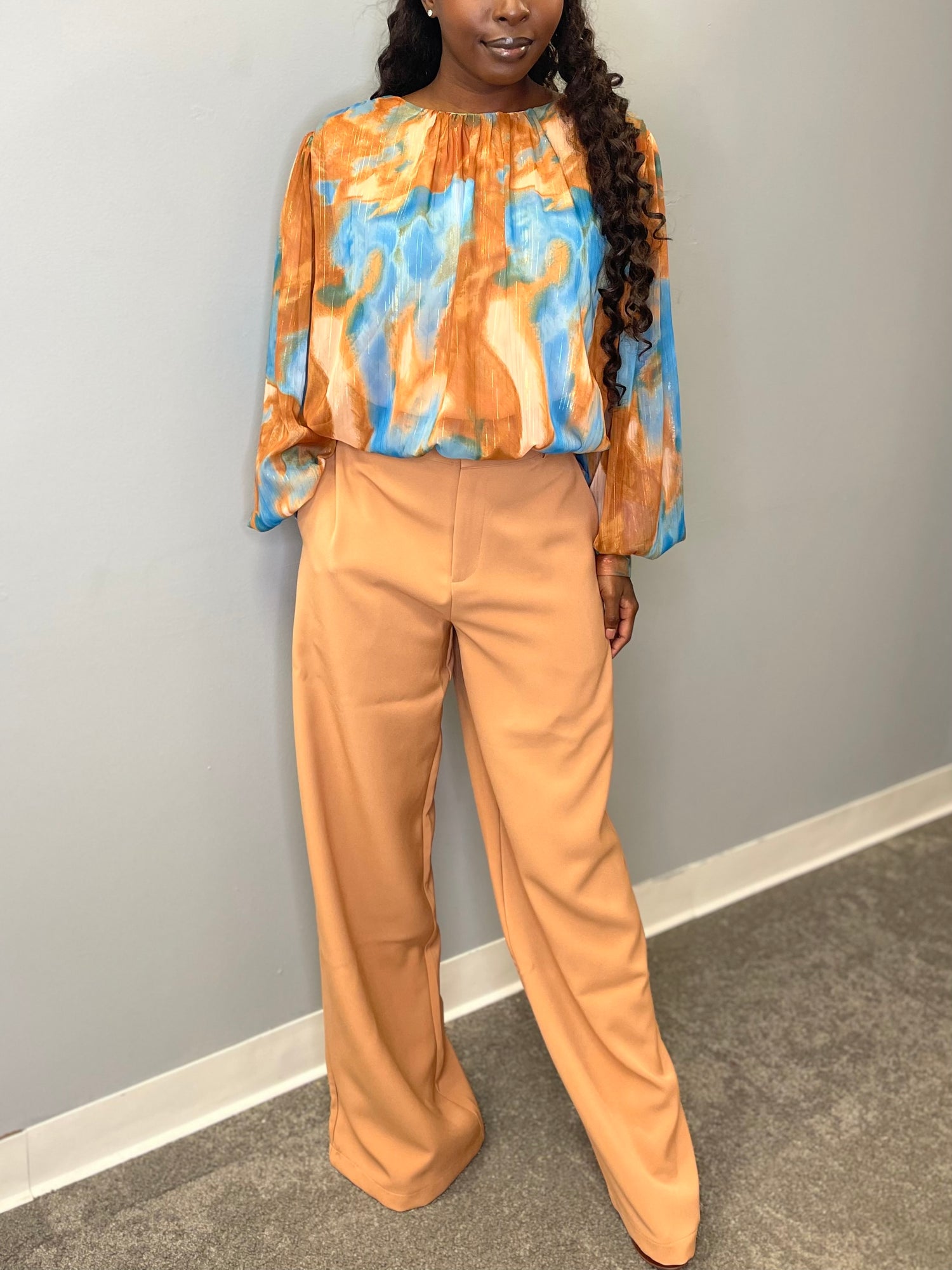 Model wearing the Evermore Woven Top in brown and blue abstract pattern, featuring a relaxed fit and lightweight fabric.