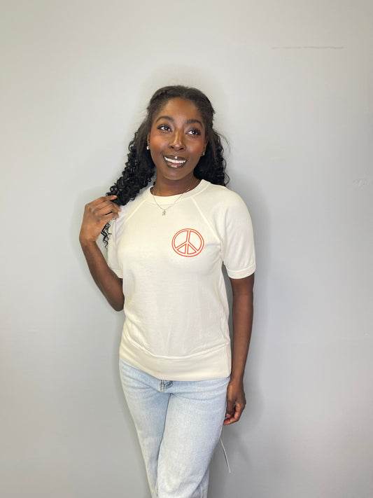 Model gazes upward with hand at her hair, showcasing the front of the Janis Joplin tee and the relaxed fit.