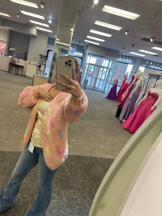 Model wearing the Lobelia Cardigan in rose pale, featuring a relaxed fit, open front, and soft ribbed knit texture.